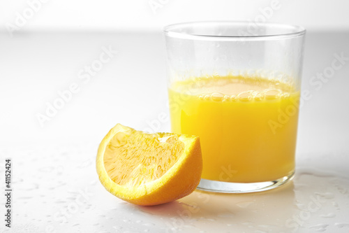 Fresh orange juice and slice of orange isolated on white