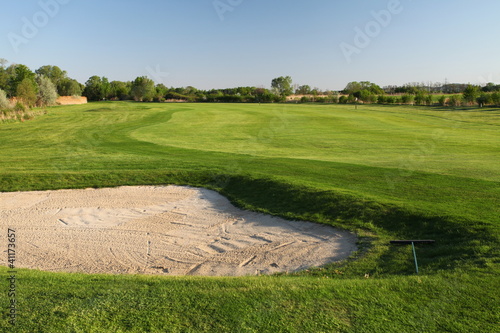 Sand bunker on the golf course with green grass
