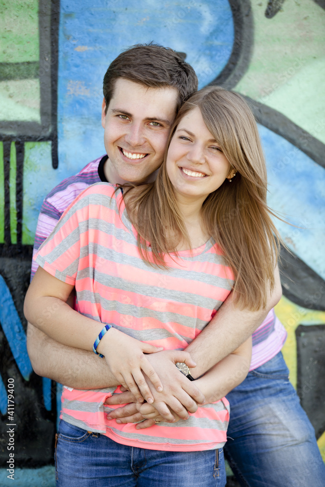 Young couple near graffiti background.