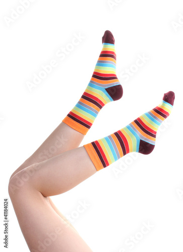female legs in colorful striped socks isolated on white