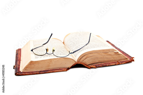 Old open bible with reading glases