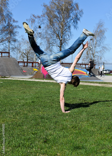 Breakdancer doing a flip on the grass.