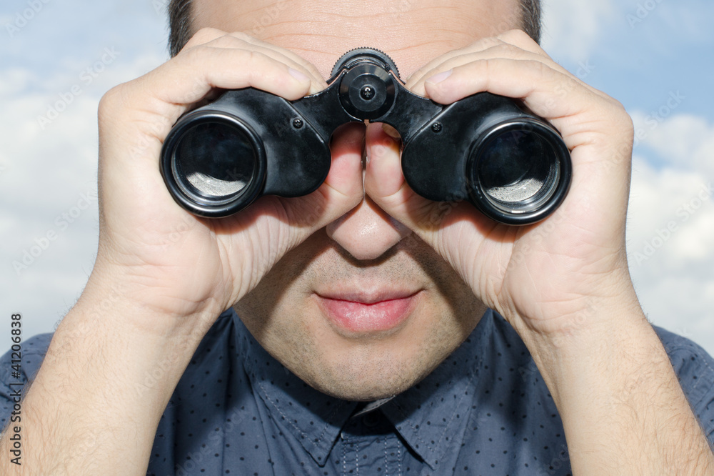 Hombre mirando por los prismaticos. Stock Photo | Adobe Stock