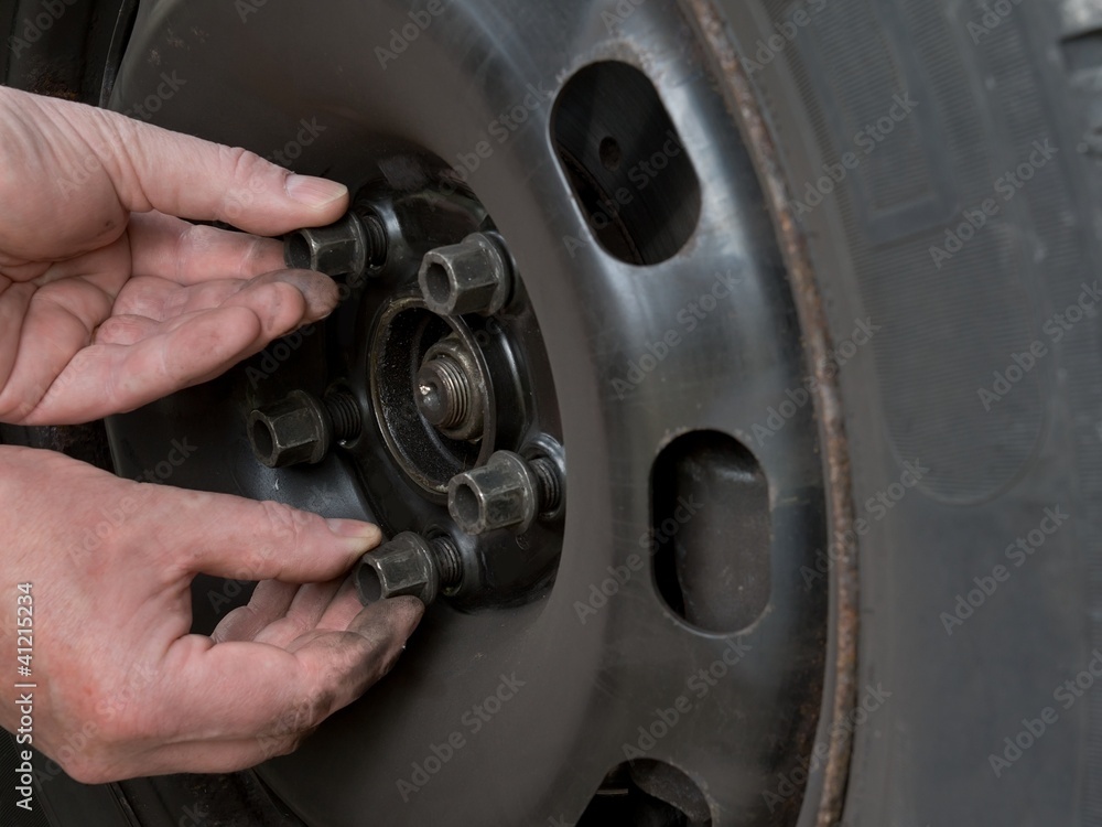 Close up photo of a mans hands changing a wheel Close up photo of a mans hands changing a wheel
