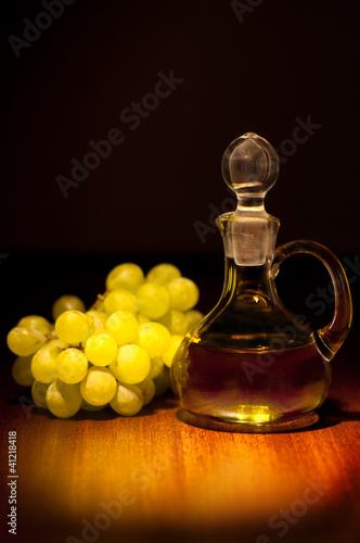 Eine Flasche Traubenkernöl und daneben Weintrauben