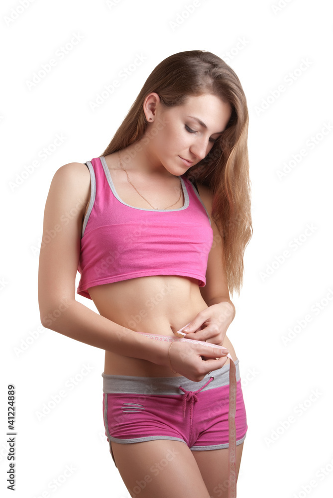 Young woman measuring her waist with a tape measure Young woman measuring her waist with a tape measure