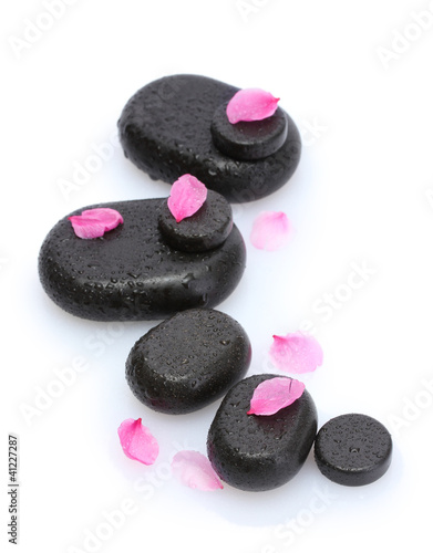 Spa stones with drops and pink petals isolated on white.