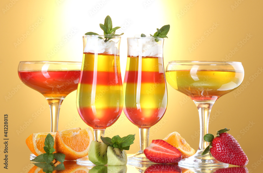 fruit jelly in glasses and fruits on yellow background fruit jelly in glasses and fruits on yellow background