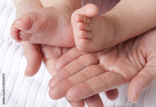 parent hands embracing baby feet