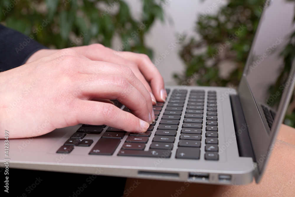 Junge Geschäftsfrau mit einem Notebook auf ihren Knien Junge Geschäftsfrau mit einem Notebook auf ihren Knien