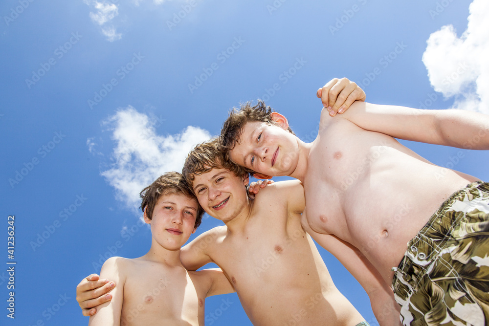 Low angle view of happy guys standing together in a circle agai Low angle view of happy guys standing together in a circle agai