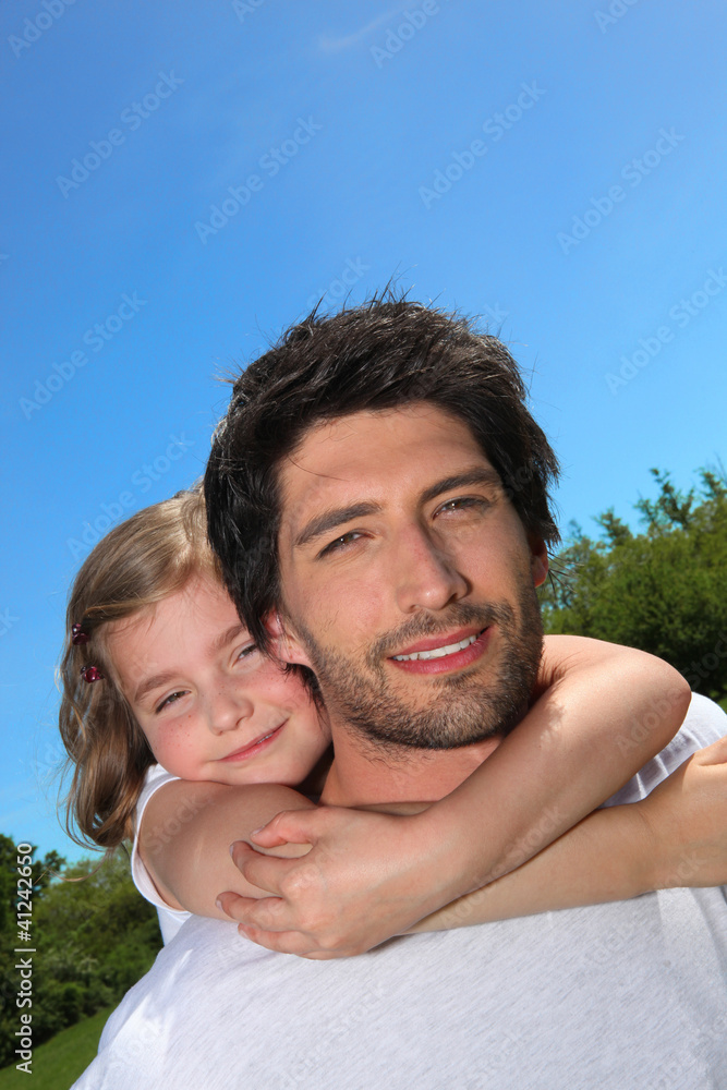 Dad giving his daughter a piggy back Dad giving his daughter a piggy back