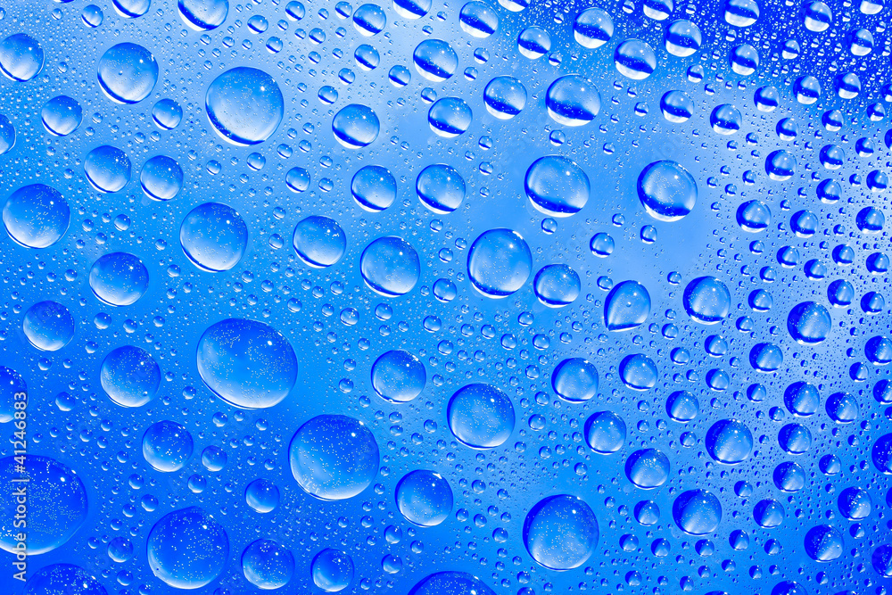 Blue water drops on the glass Blue water drops on the glass