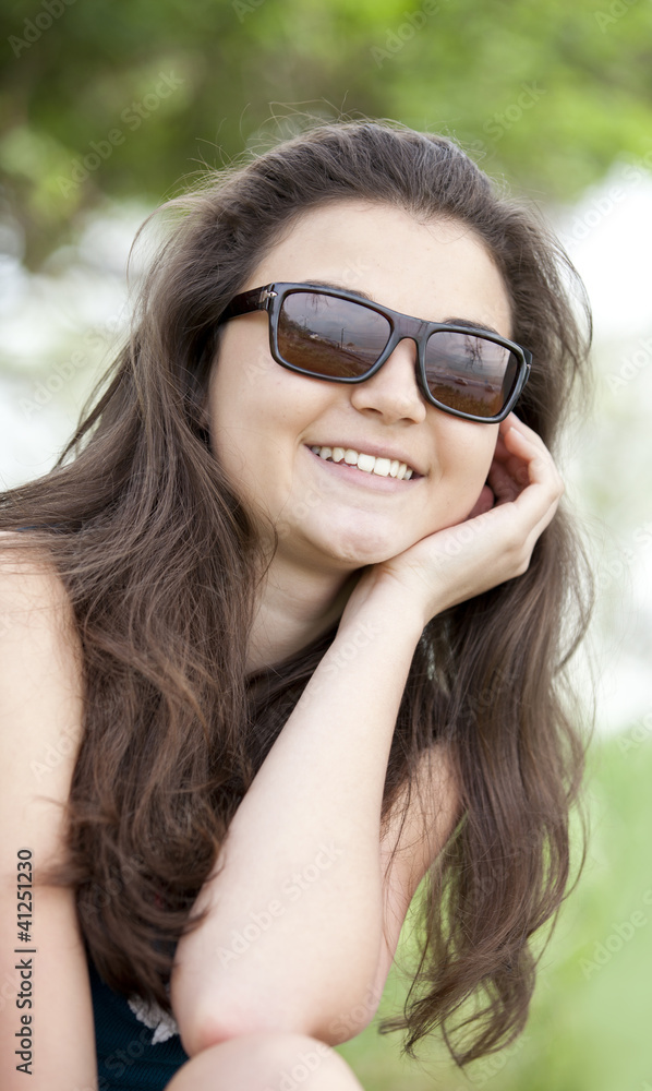 Brunette girl in sunglasses at the summer park. Brunette girl in sunglasses at the summer park.