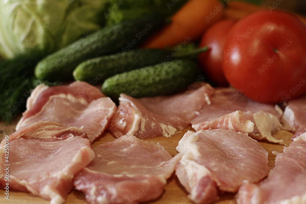 Raw pork chops and vegetables