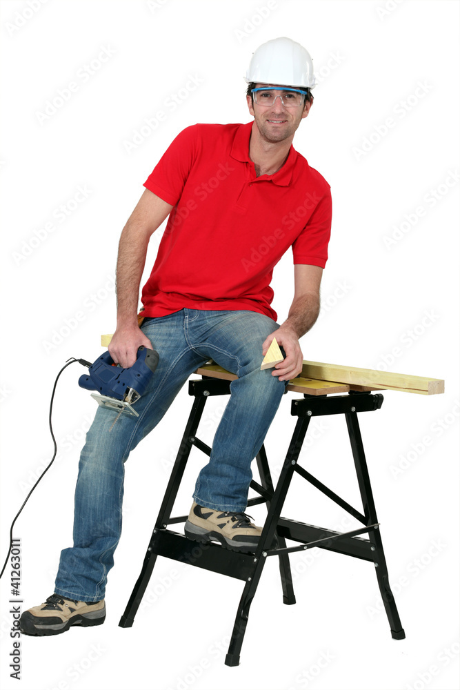 Man cutting a piece of wood with a jigsaw Man cutting a piece of wood with a jigsaw
