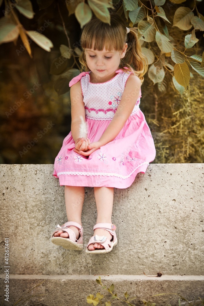 Beautiful Cute Baby Girl In Fancy Clothes With A White T-shirt, Leggings  And Sneakers Is Sitting On A Green Bench With Pillows Stock Photo, Picture  and Royalty Free Image. Image 198325248.