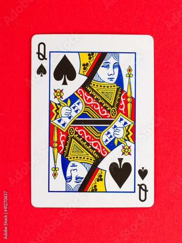 Old playing card (queen) isolated on a red background photo