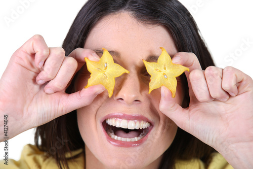 woman laughing and hiding her eyes with flowers photo