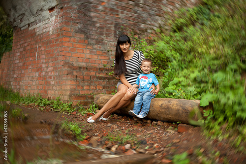 a little boy in a blue shirt with his mother