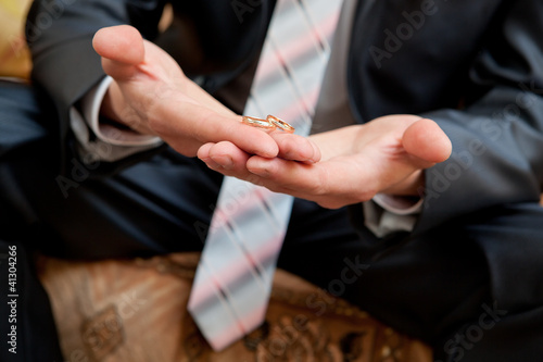 Gold wedding rings on a hand of the groom © lexuss