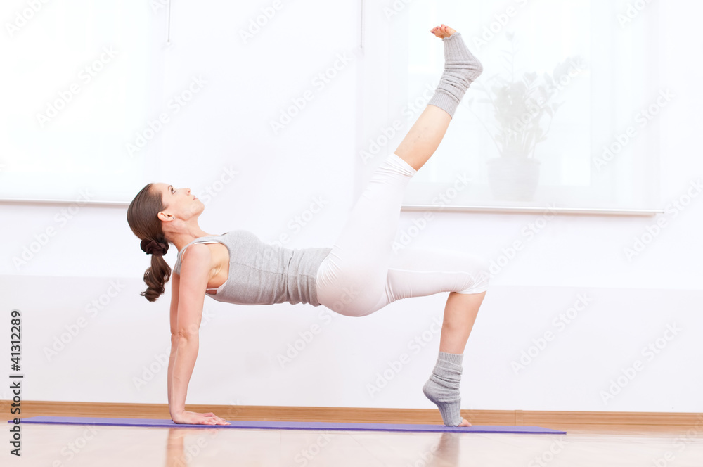 Woman doing stretching yoga exercise at sport gym Woman doing stretching yoga exercise at sport gym