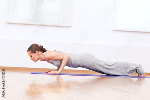 Woman doing stretching yoga exercise at sport gym