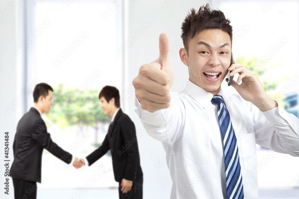 successful businessman on the phone with thumbs up successful businessman on the phone with thumbs up