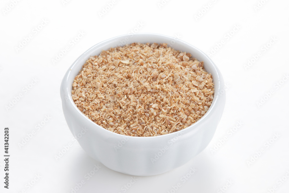 Coriander ground (Coriandrum sativum) in a white bowl on white b Coriander ground (Coriandrum sativum) in a white bowl on white b