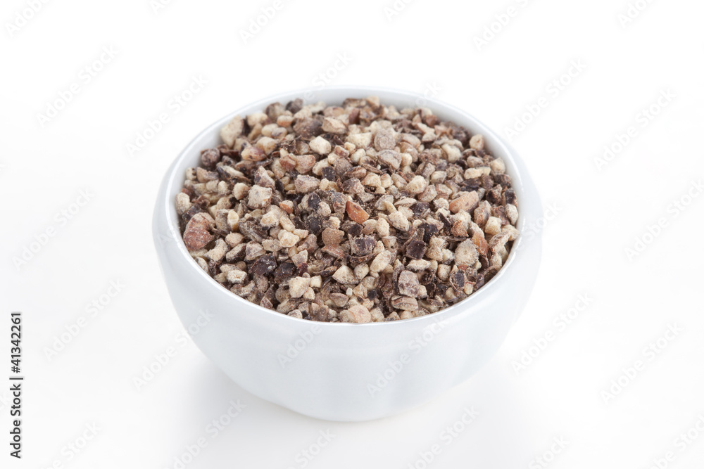 Crushed Black pepper (Piper nigrum) in a white bowl on white bac Crushed Black pepper (Piper nigrum) in a white bowl on white bac