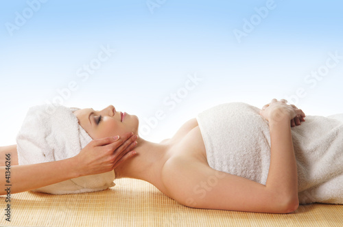 A young woman laying on a spa procedure in a cotton towel