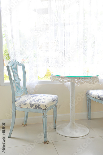 A vintage chair near a window © sutsaiy