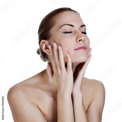 Beautiful young woman massaging her face