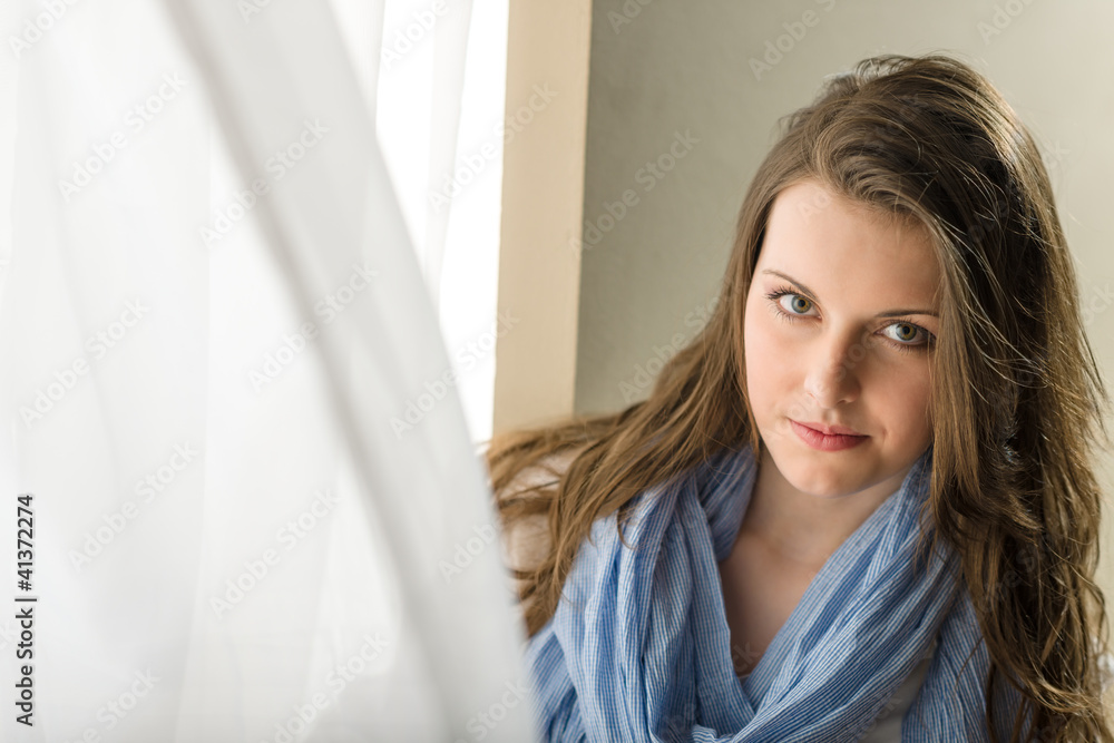 Brunette young woman behind blowing curtain Brunette young woman behind blowing curtain