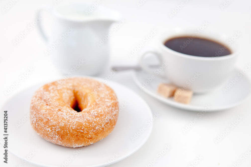 Doughnut with icing sugar and a cup of coffee on white plates wi Doughnut with icing sugar and a cup of coffee on white plates wi