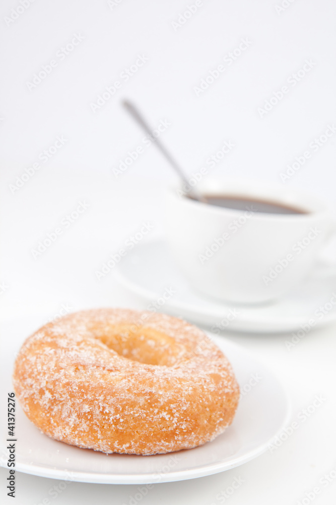 Doughnut with icing sugar and a cup of coffee with spoon on whit Doughnut with icing sugar and a cup of coffee with spoon on whit