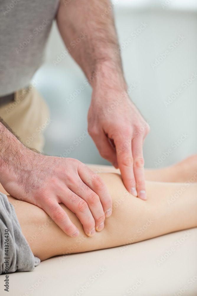 Physiotherapist pressing the calf of a patient Physiotherapist pressing the calf of a patient