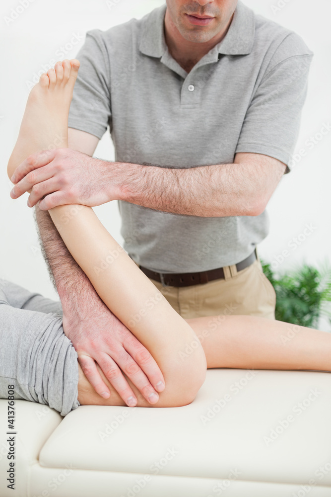 Close-up of a men stretching the leg of a woman Close-up of a men stretching the leg of a woman