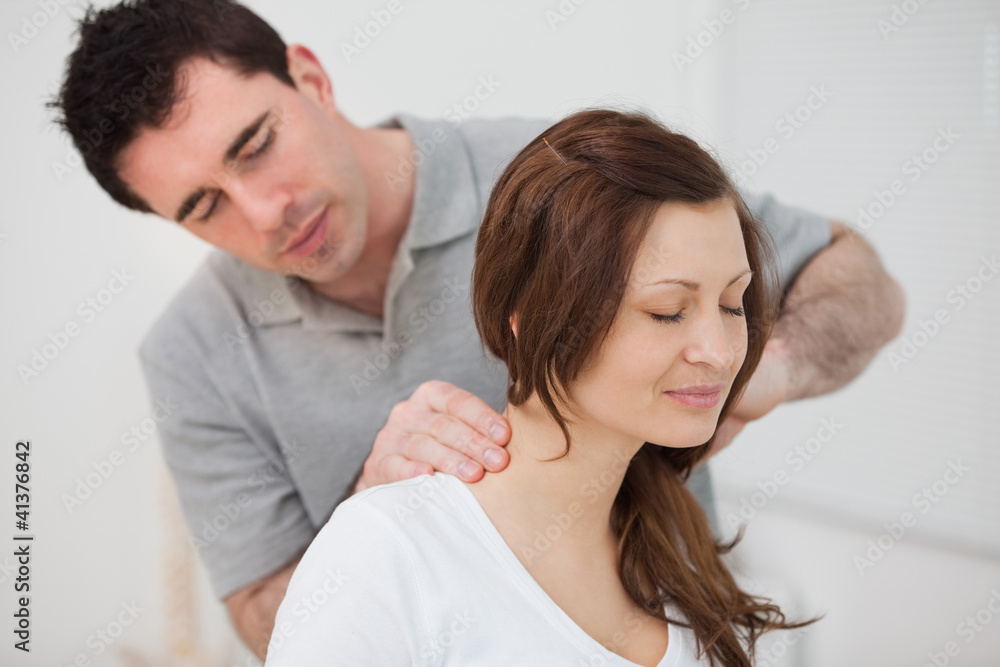 Smiling woman sitting while being massaged by a man Smiling woman sitting while being massaged by a man