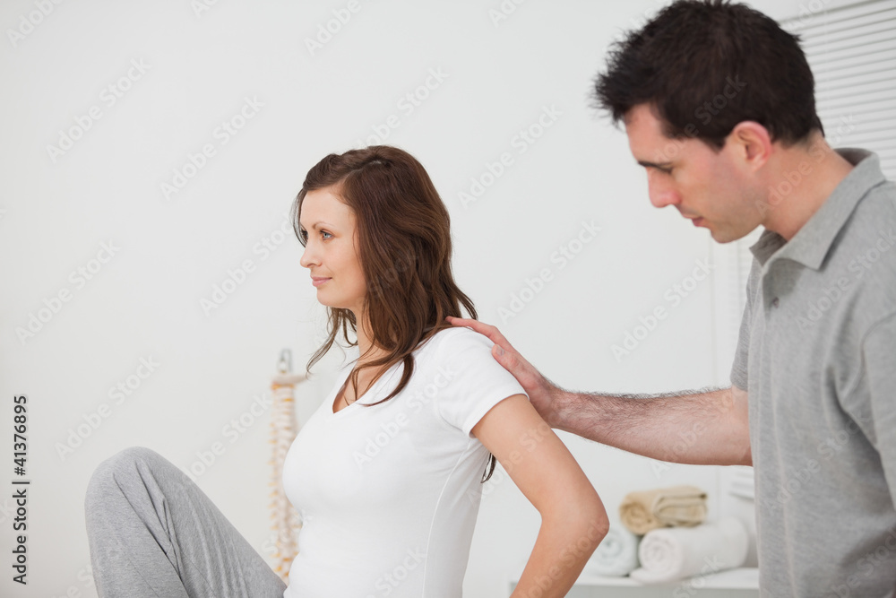 Woman sitting while a man is touching her back Woman sitting while a man is touching her back