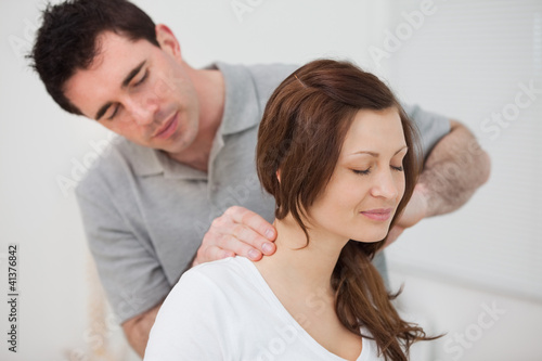 Canvastavla Smiling woman sitting while being massaged by a man
