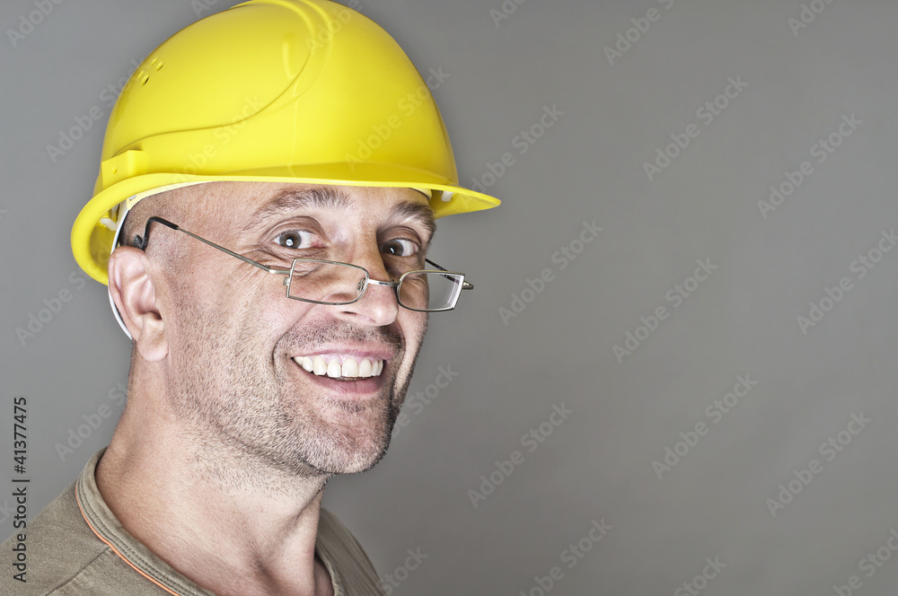 Freundlich lächelnder Arbeiter mit Lesebrille Freundlich lächelnder Arbeiter mit Lesebrille