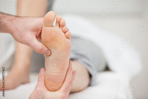Doctor holding the foot of a woman photo