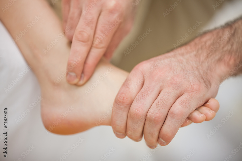Physiotherapist massaging a barefoot