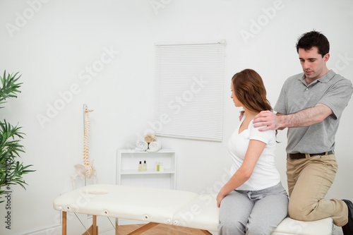 Osteopath looking at the back of a woman © WavebreakmediaMicro