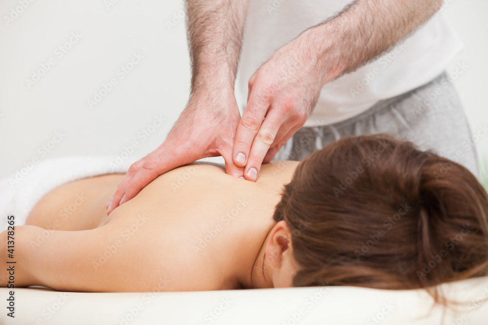 Fototapeta premium Therapist massaging the top of back of woman while standing