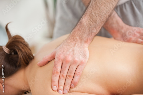 Woman lying on the belly while being massaged on his back