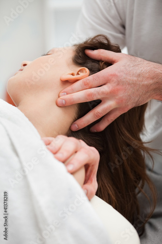 Close-up of chiropractor manipulating the neck of his patient photo