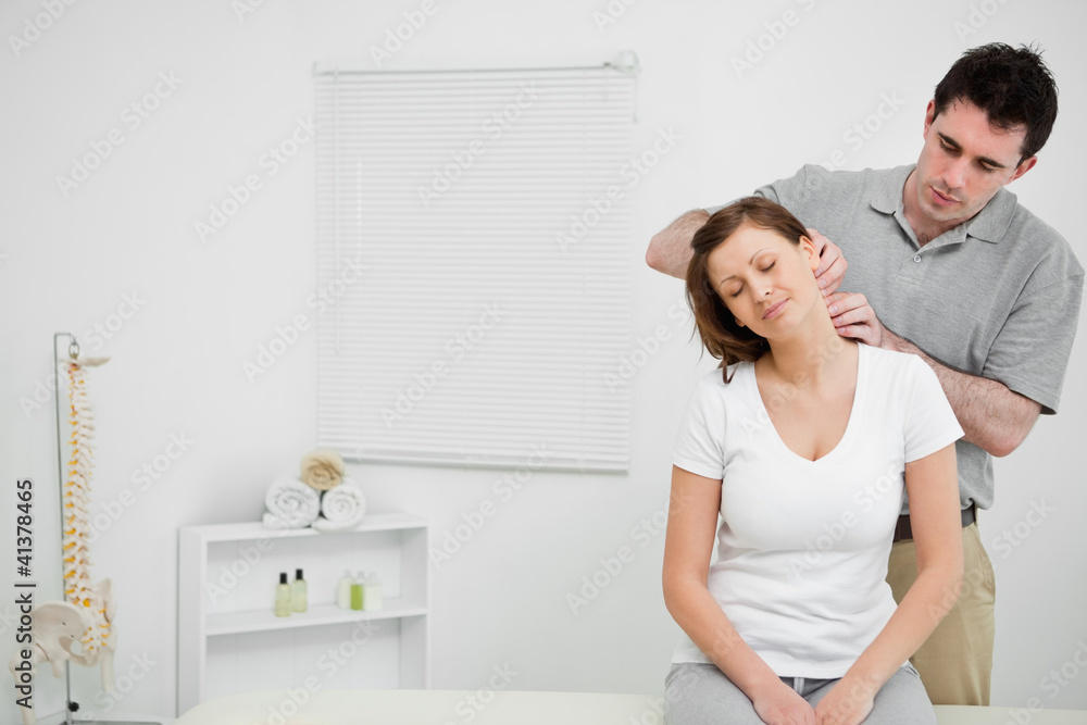 Doctor examining the neck of his patient while standing Doctor examining the neck of his patient while standing
