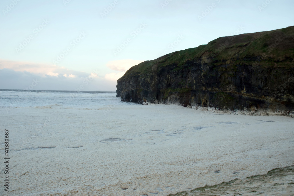 sweeping waves of foam beside cliffs